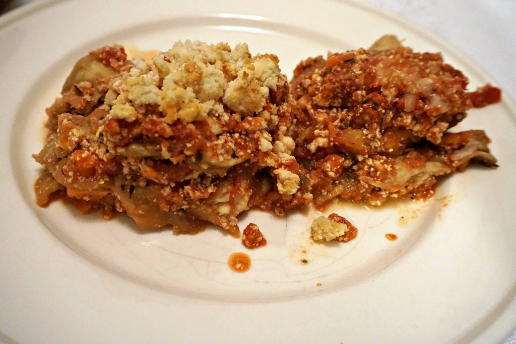 Portions of Vegan Eggplant Lasagna and Vegetarian Eggplant Lasagna side by side on a white plate